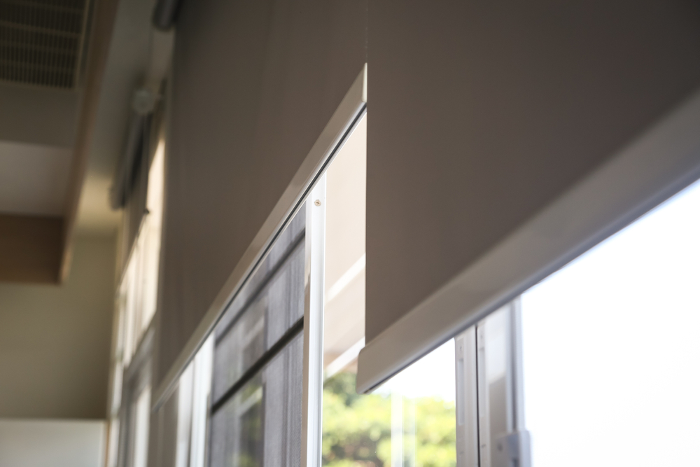 White fabric roller blinds installed on a modern window